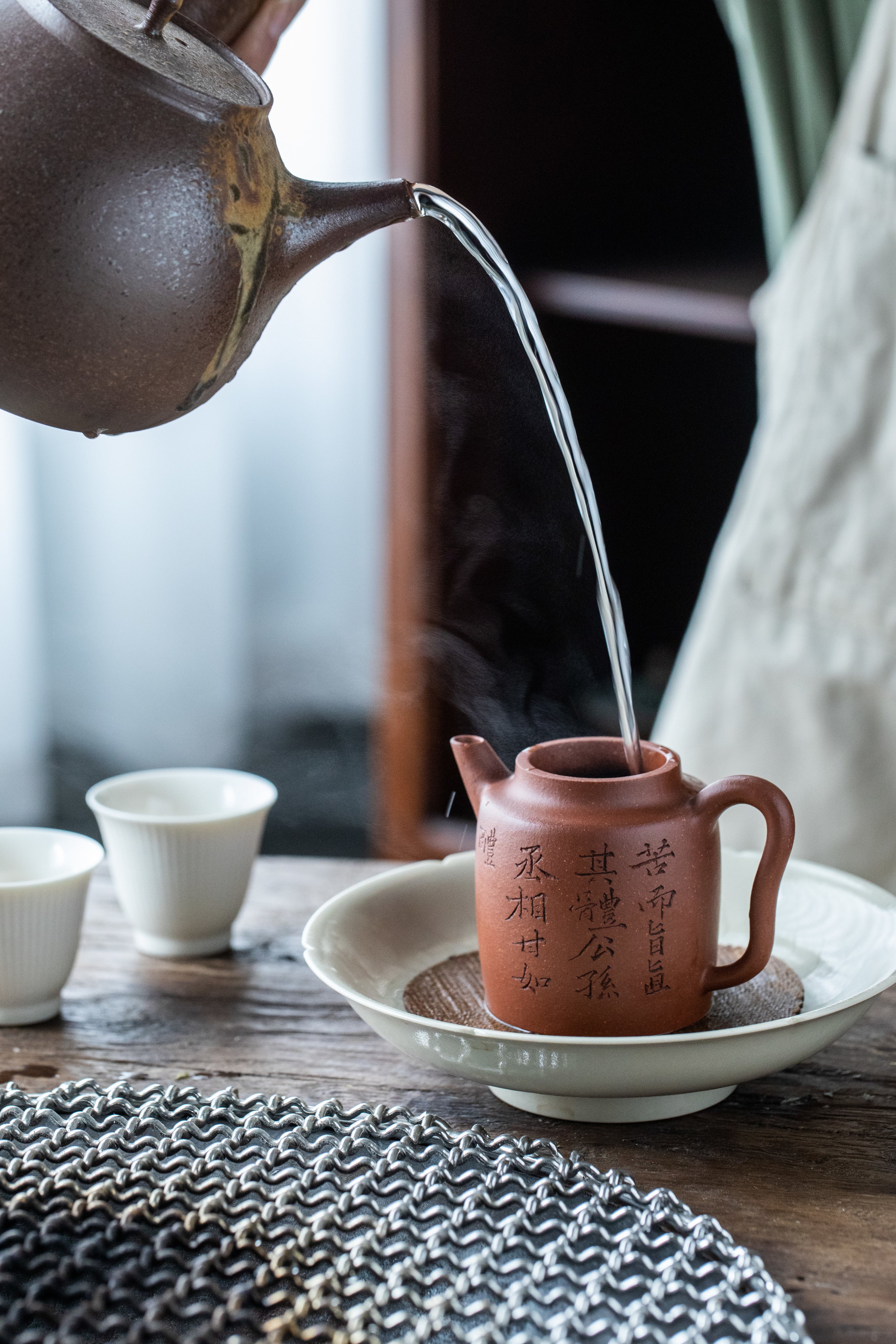 water poured into a chinese yixing zisha tea pot for the brewing of luxury Chinese loose tea leaves 